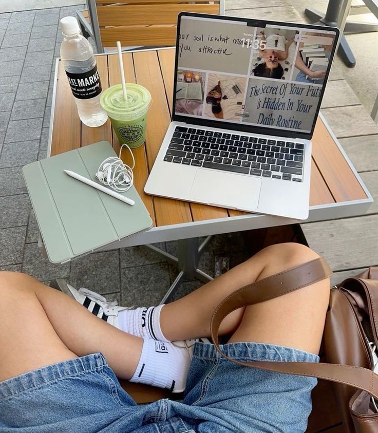 4809db8f-1570-477e-b10a-4c182945be2e - Handy Home Laptop on outdoor cafe table with matcha drink, tablet, and water bottle. Relaxing workspace with a motivational message on screen.