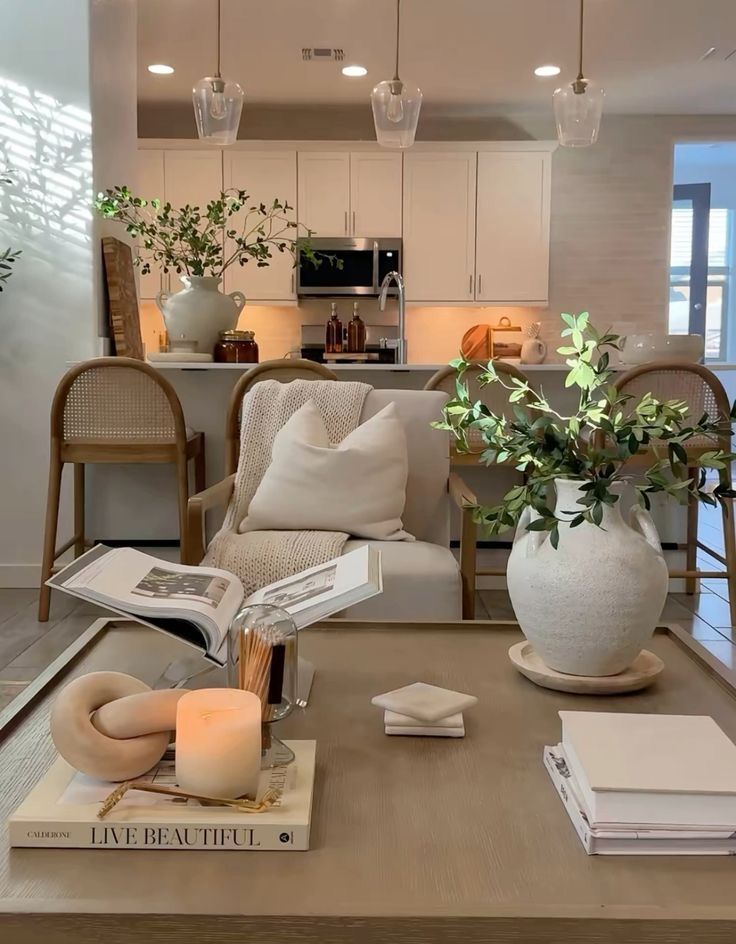 5b98b5dc-a494-4f9c-a348-58e67d6e271d - Handy Home Modern living room with cozy seating, decorative plants, and an elegant kitchen in the background under pendant lighting.