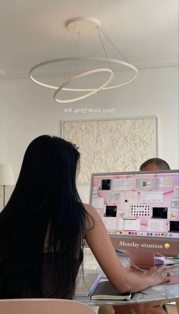 7884630f-457f-4b3c-8e0d-874636d5389c - Handy Home Person working at a desk with a computer, illuminated by modern circular ceiling lights in a minimalistic room.