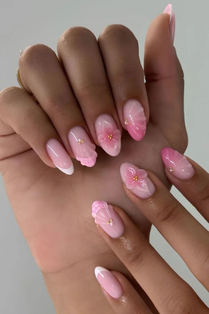 87ca9099-17cd-4d96-8f52-7fb6143d7ea3 - Handy Home Elegant pink and white floral nail art with gold accents, showcasing intricate 3D designs on manicured hands.