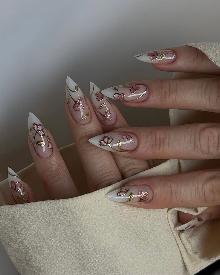 COMPRE AQUI NO LINK ABAIXO - Handy Home Elegant stiletto nails with floral design, featuring pink blossoms and gold accents on a white base. Perfect for a chic manicure look.