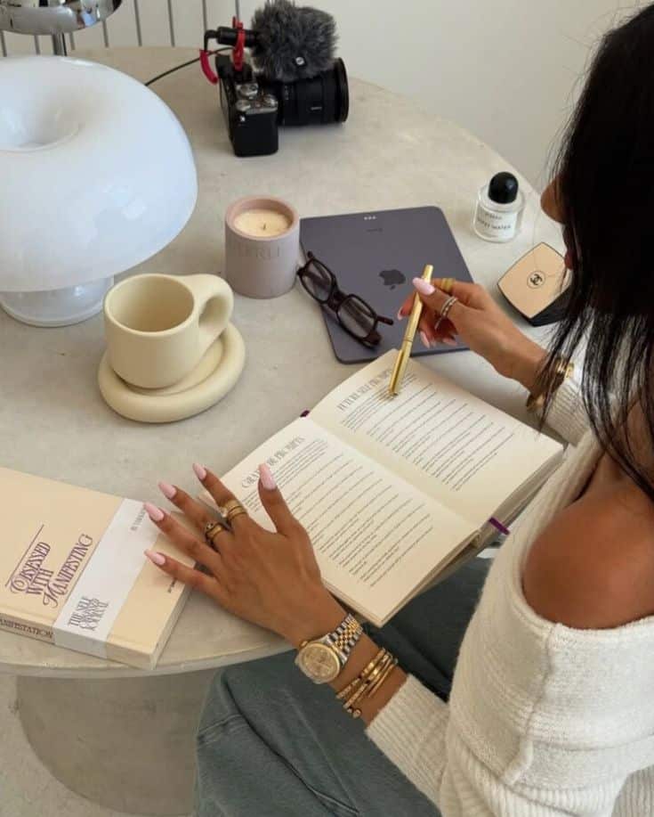 Cozy Morning Routine with Journaling - Handy Home Person writing notes in a book at a cozy desk with a camera, laptop, and coffee mug; perfect for productivity and inspiration.