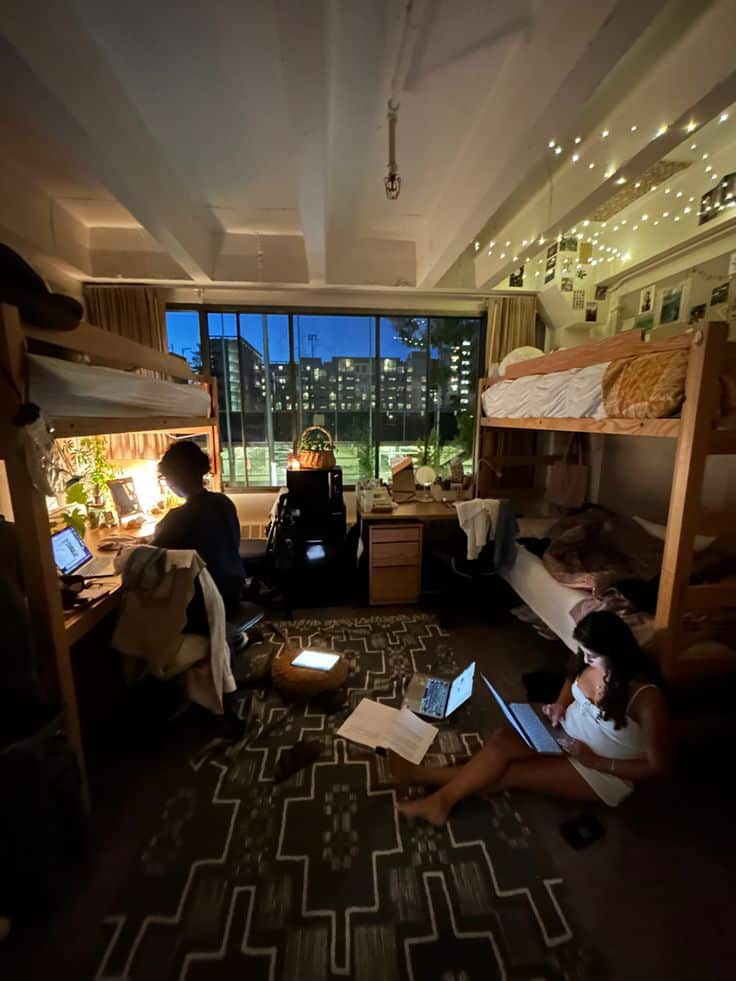 Dream dorm UC Berkeley fairy bedroom city lights Cozy college dorm room with students studying at night, using laptops under warm string lights and bunk beds. - Handy Home Cozy college dorm room with students studying at night, using laptops under warm string lights and bunk beds.