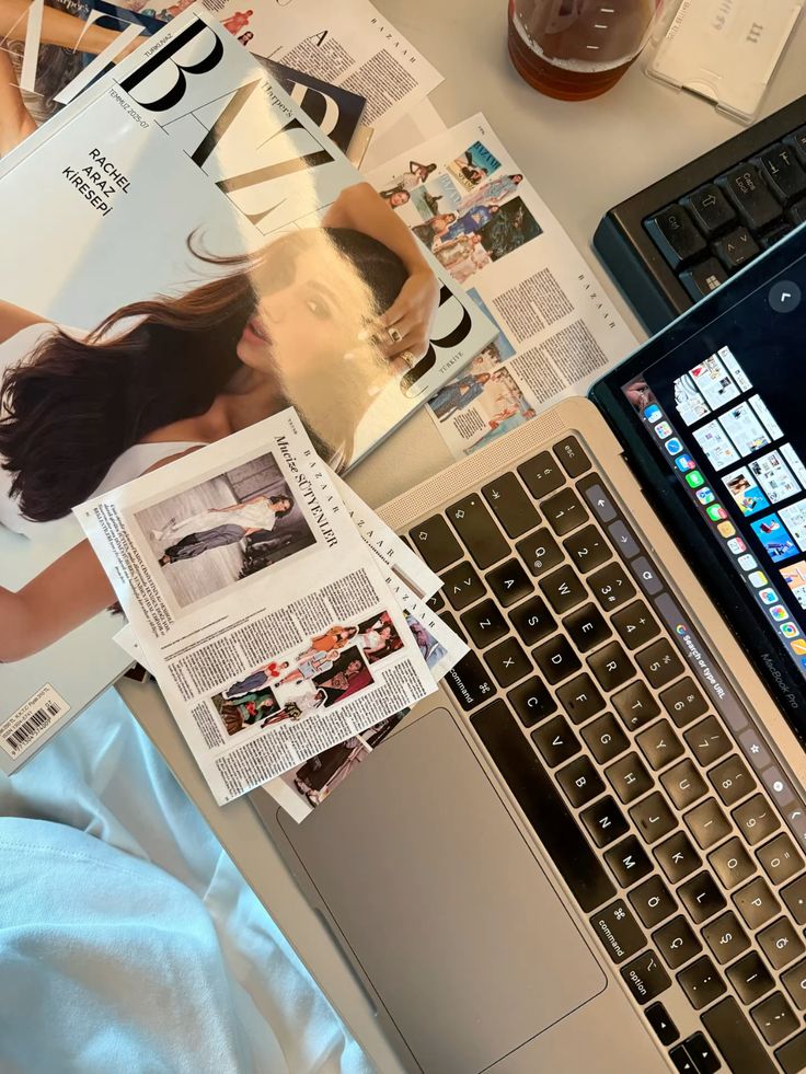 Magazine editor - Handy Home Laptop and fashion magazines on a workspace, featuring editorial layouts and designer collections. Ideal for fashion content creation.