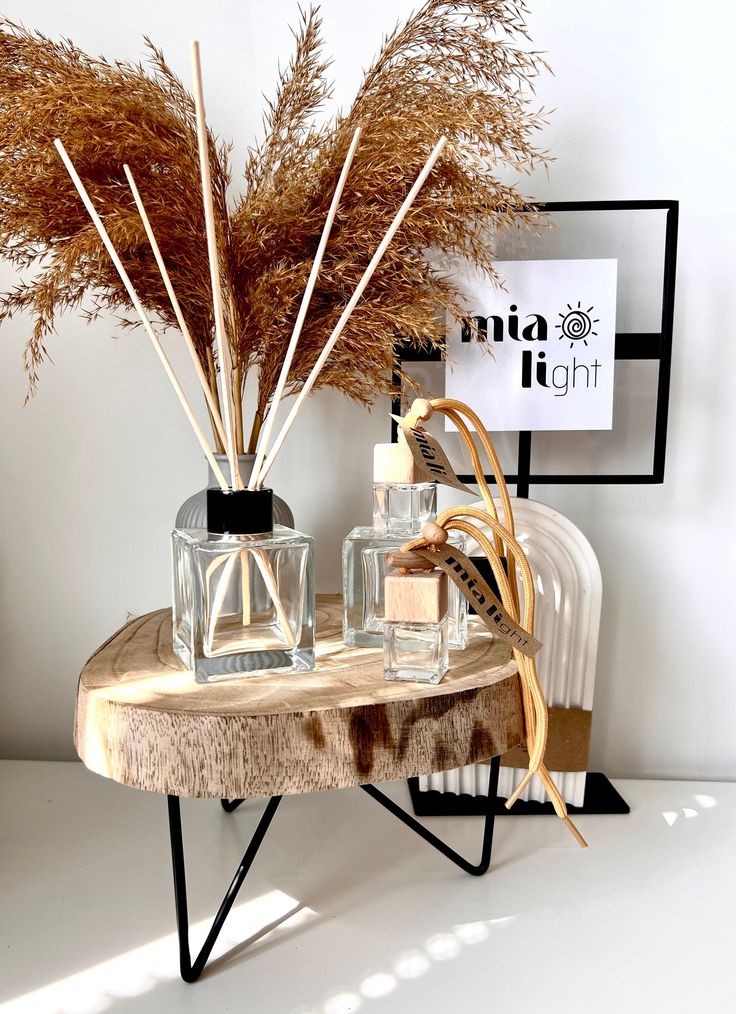 Minimalist Glass Home Fragrance Diffuser with Reed Sticks Refillable 100ml Scented Decor Gift Eco friendly - Handy Home Decorative reed diffusers on a wooden stand, adorned with dried pampas grass, enhancing a minimalist home decor setting.