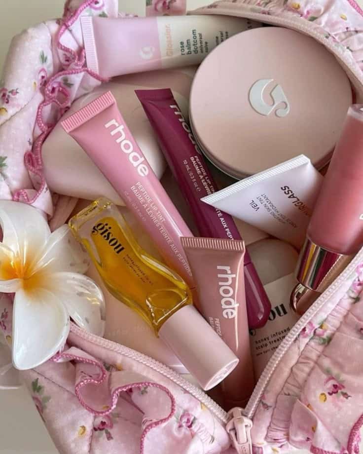 Pink matcha drink matcha gym grwm get ready - Handy Home Pink floral makeup bag with various makeup products, including lip tints, balm, and oil. Flatlay featuring beauty essentials.