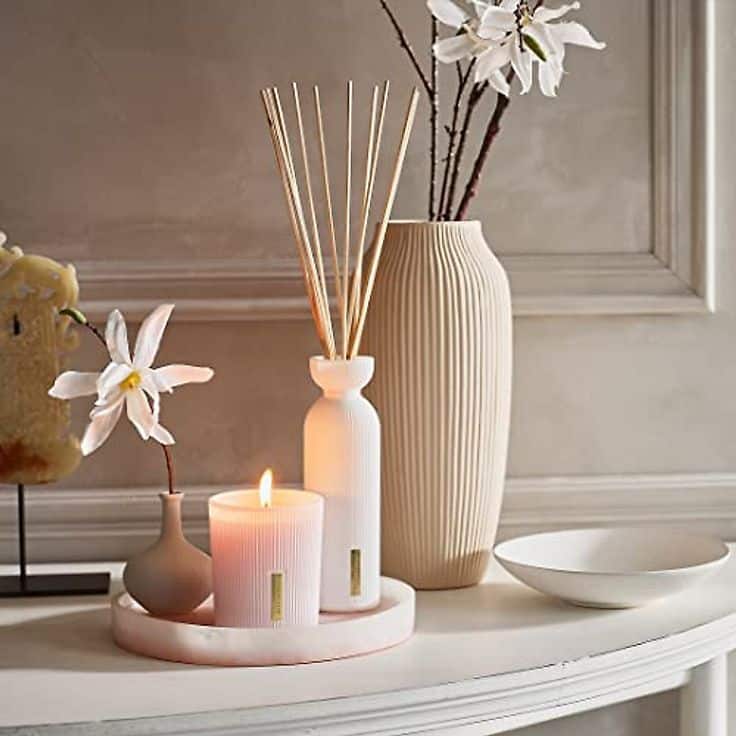 RITUALS Sakura Oil Reed Diffuser Set - Fragrance Sticks with Rice Milk and Cherry Blossom - 2_3 Fl Oz - Handy Home Elegant home decor with lit candle, reed diffuser, and floral arrangements on a white tray, creating a serene ambiance.