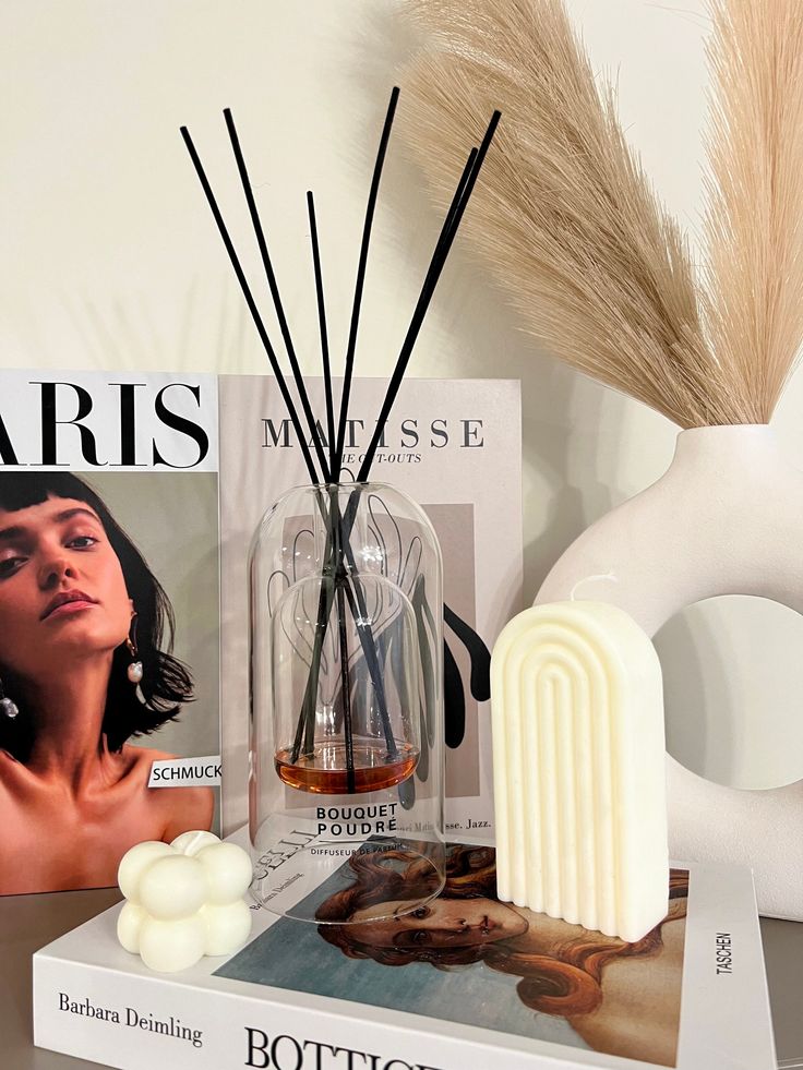 Reed diffuser floral diffuser home fragrance preserved flower essential oil made in France gift home decor 150ml or 300ml - Handy Home Modern decor with minimalist candles, reed diffuser, and art books displayed on a shelf for a stylish home aesthetic.