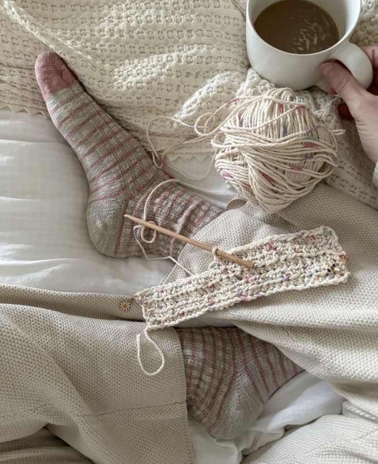 Sierra Romanova_ - Handy Home Cozy knitting scene with striped socks, yarn, and a relaxing cup of coffee, perfect for winter crafting and comfort.