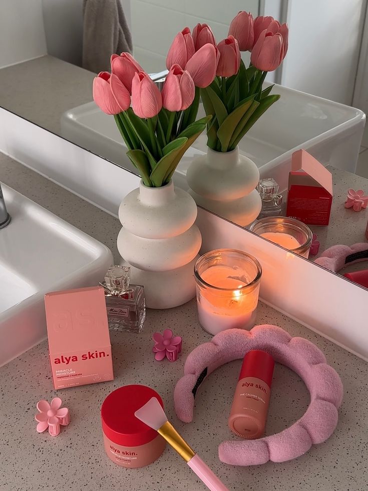 Skin care solutions - Handy Home Pink tulips in vase with skincare products, candle, and hairband on bathroom counter. Cozy self-care setup.