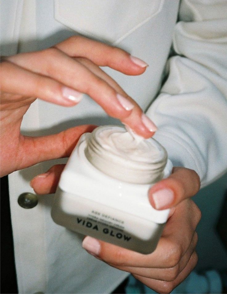 Why marine collagen is the answer your dry skin has been waiting for - Handy Home Hands applying creamy moisturizer from a jar, labeled Vida Glow, for skin nourishment and hydration.