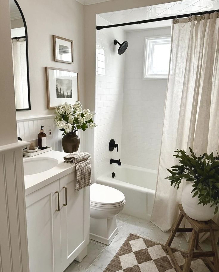 a2db20ff-6b25-484d-aece-bfa285dbcabd - Handy Home Modern bathroom with white decor, plants, and a rainfall showerhead, showcasing minimalist design and natural lighting.