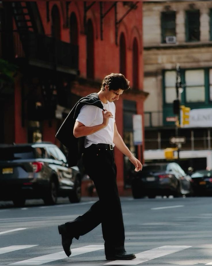 a86eea93-3700-43d9-a4b6-0ada4d378c1a - Handy Home Stylish man in urban setting crossing the street in casual attire, holding jacket over his shoulder.