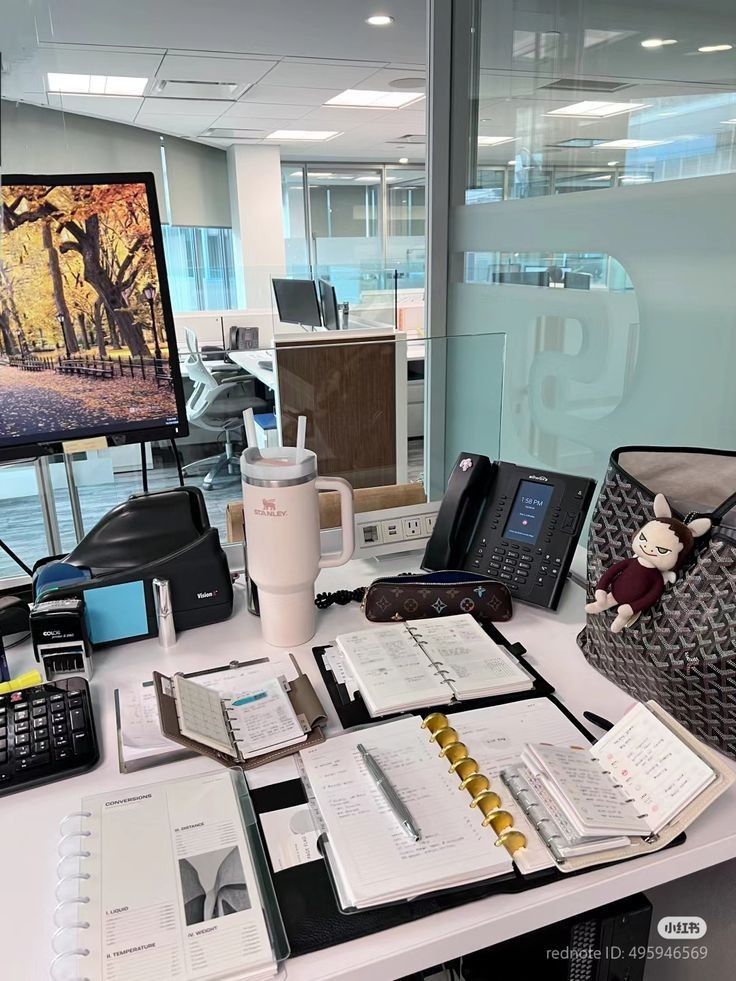 b17e176a-3c2b-4f4a-9d93-d504471f0310 - Handy Home Modern office desk with planners, laptop, phone, and a scenic screen background, showcasing productivity and organization.