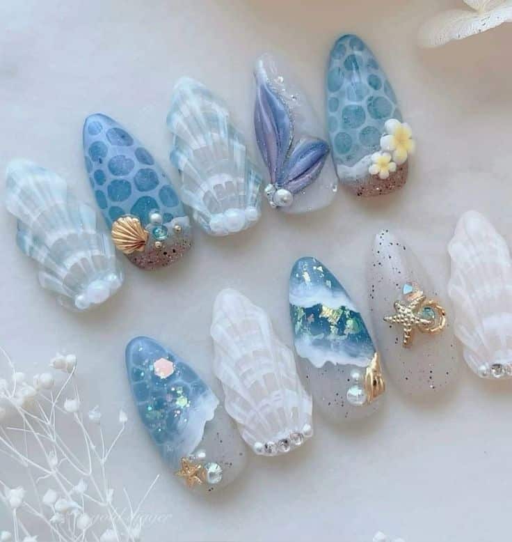 cc cest kailou💙 Nail art ocean 🏝️ - Handy Home Ocean-themed nail art with seashell, starfish, and pearl designs in blue and white tones. Perfect for a beach-inspired look.