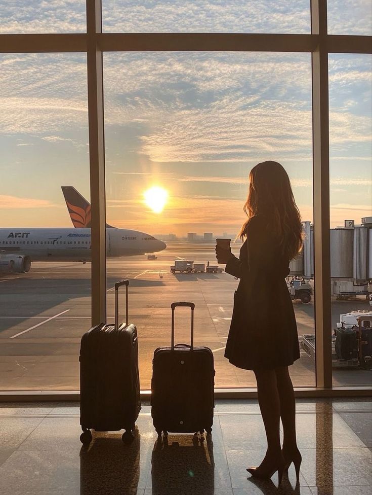 eb33db41-20b8-4aa9-984f-6b18a4246933 - Handy Home Silhouette of a woman with luggage, gazing at sunrise through airport window, airplane on the tarmac, travel concept.