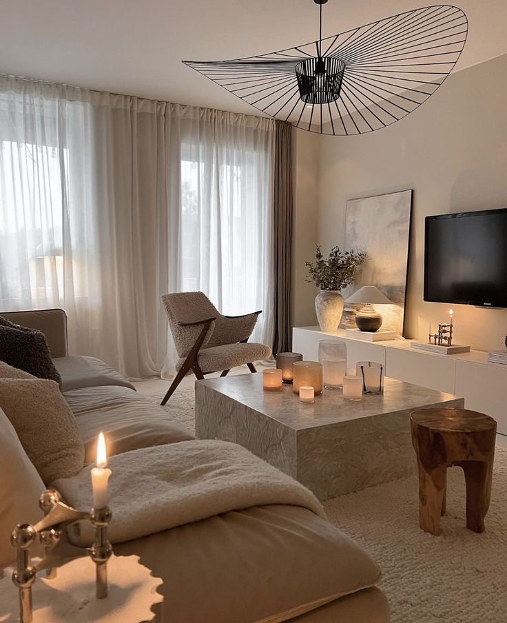 f4bc1c2a-1a9d-4b38-b894-a0989b73b8b2 - Handy Home Cozy modern living room with elegant lighting, plush sofa, candles on a stone coffee table, and minimalist decor. Warm, inviting atmosphere.