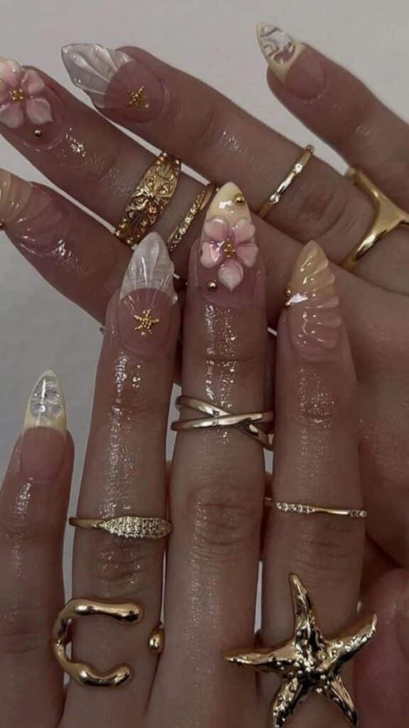 ff07d810-db77-4ad1-9995-9f6cae990a5a - Handy Home Unique floral nail art and gold rings on manicured hands, featuring delicate designs and intricate jewelry.