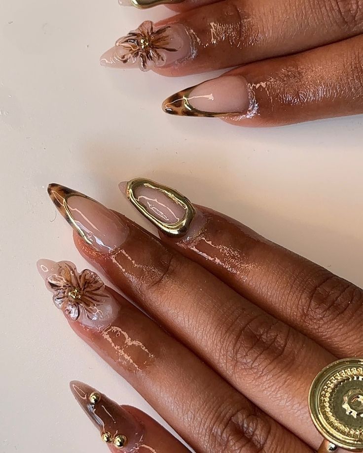 nail inspo - Handy Home Elegant 3D floral nail art with gold accents on glossy, manicured hands, showcasing intricate nail design trends.
