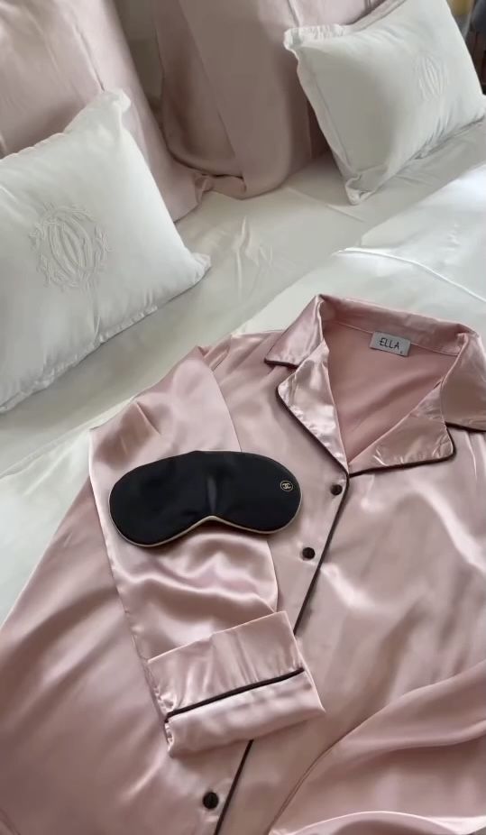silk sleepwear - Handy Home Silk pink pajamas and sleep mask on a neatly made bed with white pillows, offering a cozy and luxurious sleep setup.