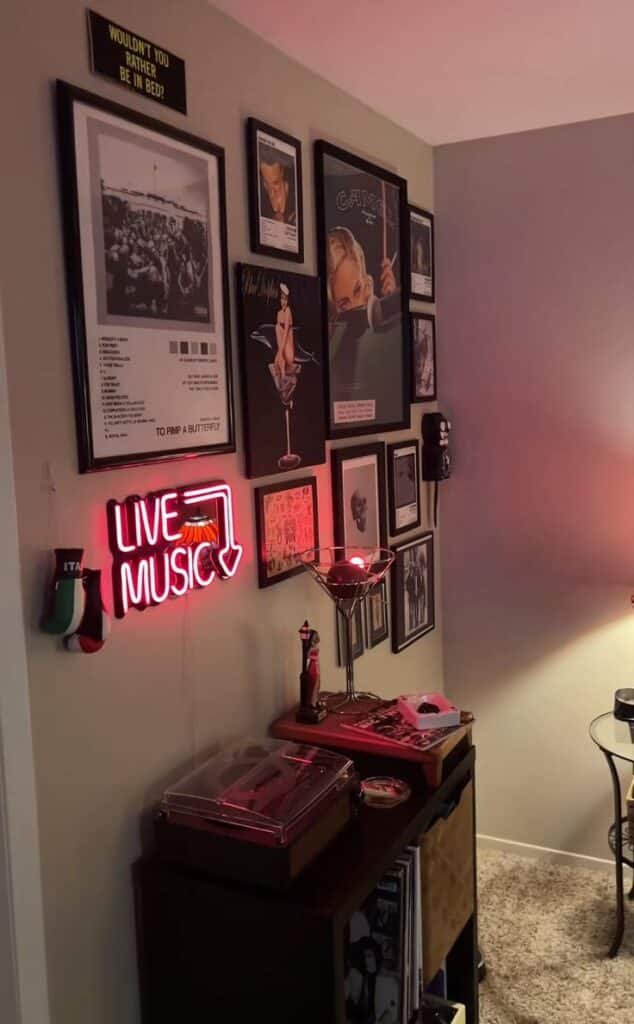 Cozy music-themed room with neon Live Music sign, framed art, and a turntable on a shelf, creating a vintage vibe.