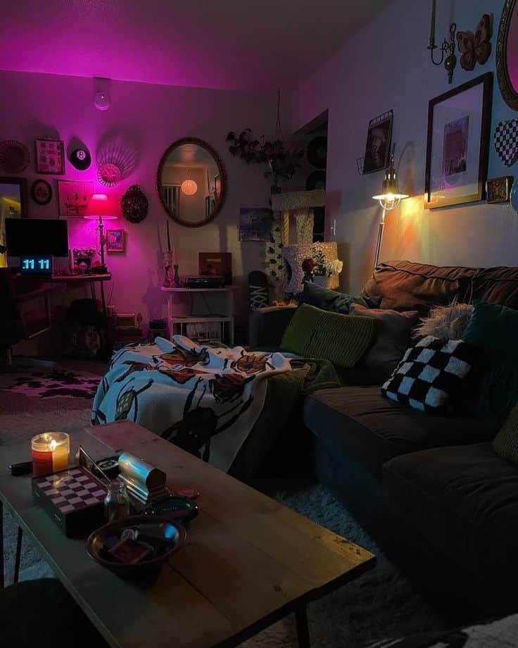 Cozy living room with dim lighting, pink and blue lamps, candles, and eclectic decor creating a relaxing atmosphere.