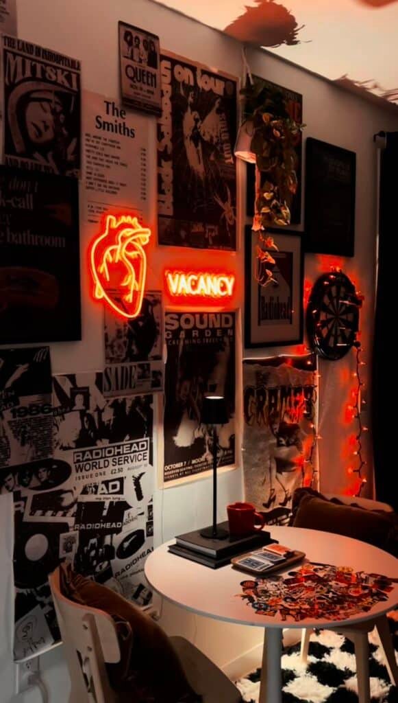 Cozy room with neon lights, vintage posters, a small round table, and wall decor creating a retro vibe.