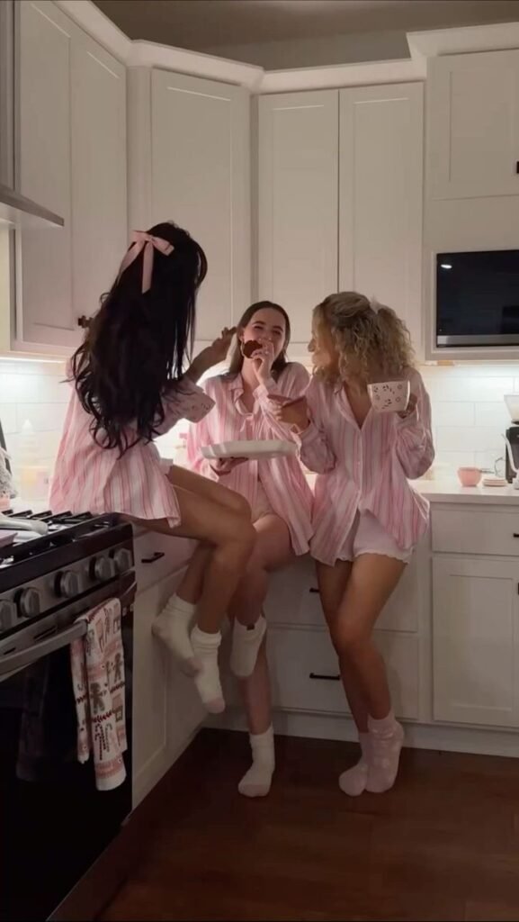 42e6479d-33c4-408f-808f-11e8ac722ca8 Three friends enjoy a cozy kitchen moment in matching pink pajamas, sharing cookies and smiles. - Handy Home Three friends enjoy a cozy kitchen moment in matching pink pajamas, sharing cookies and smiles.