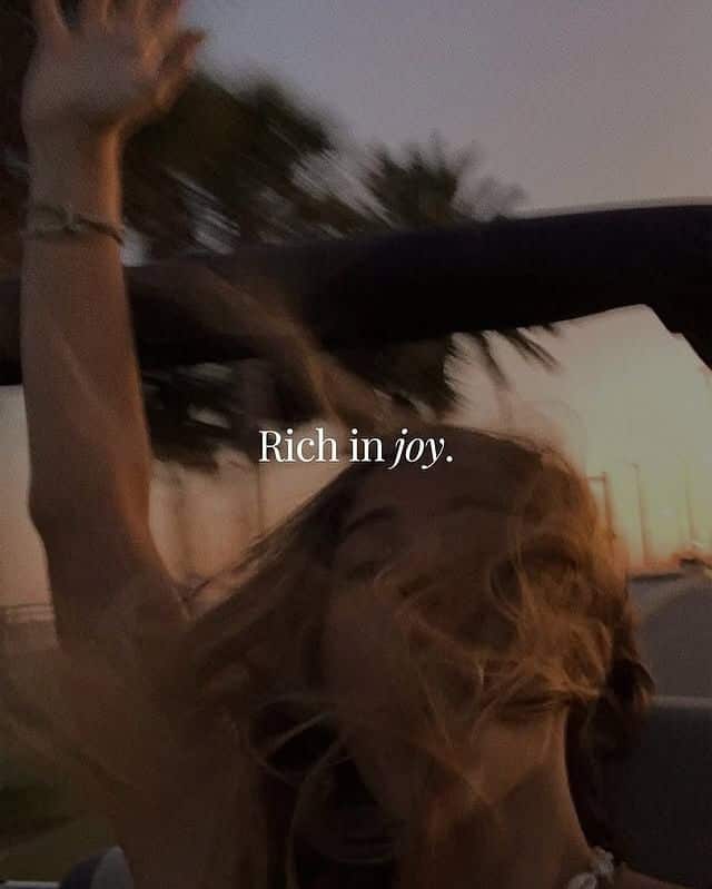 730b3ce4-5d49-424f-ad2d-52e2cf7b0027 A person joyfully rides in a convertible at sunset with hair flowing, capturing a carefree moment. Text: Rich in joy. - Handy Home A person joyfully rides in a convertible at sunset with hair flowing, capturing a carefree moment. Text: Rich in joy.