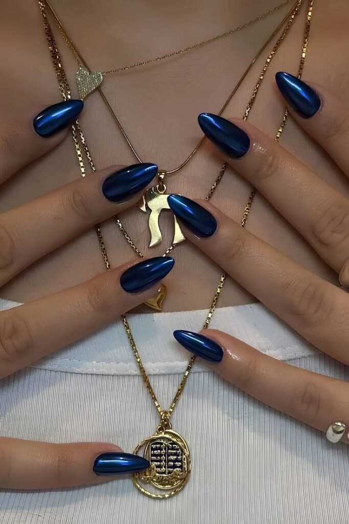 8faab2b7-56f0-4baa-9000-6b295f2917ec Close-up of elegant blue nails with layered gold necklaces featuring unique pendants on a white top. Fashion and style vibes. - Handy Home Close-up of elegant blue nails with layered gold necklaces featuring unique pendants on a white top. Fashion and style vibes.