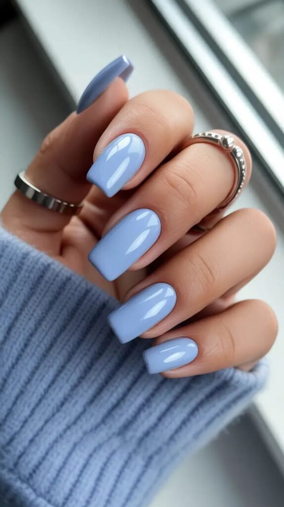 Blue Nail Designs 2026_ Trendy Winter Summer Styles to Save Now Light blue polished nails with silver rings, cozy sweater, and natural light for a chic, stylish look. - Handy Home Light blue polished nails with silver rings, cozy sweater, and natural light for a chic, stylish look.