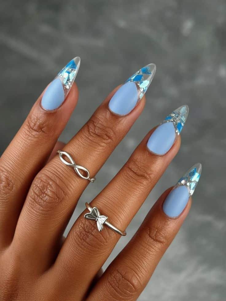 Blue Winter Nails 2025-2026 With Transparent Tips And Shiny Frozen Crystal Effect Stylish blue and clear coffin nails with geometric accents, featuring silver infinity and butterfly rings. Trendy manicure design. - Handy Home Stylish blue and clear coffin nails with geometric accents, featuring silver infinity and butterfly rings. Trendy manicure design.