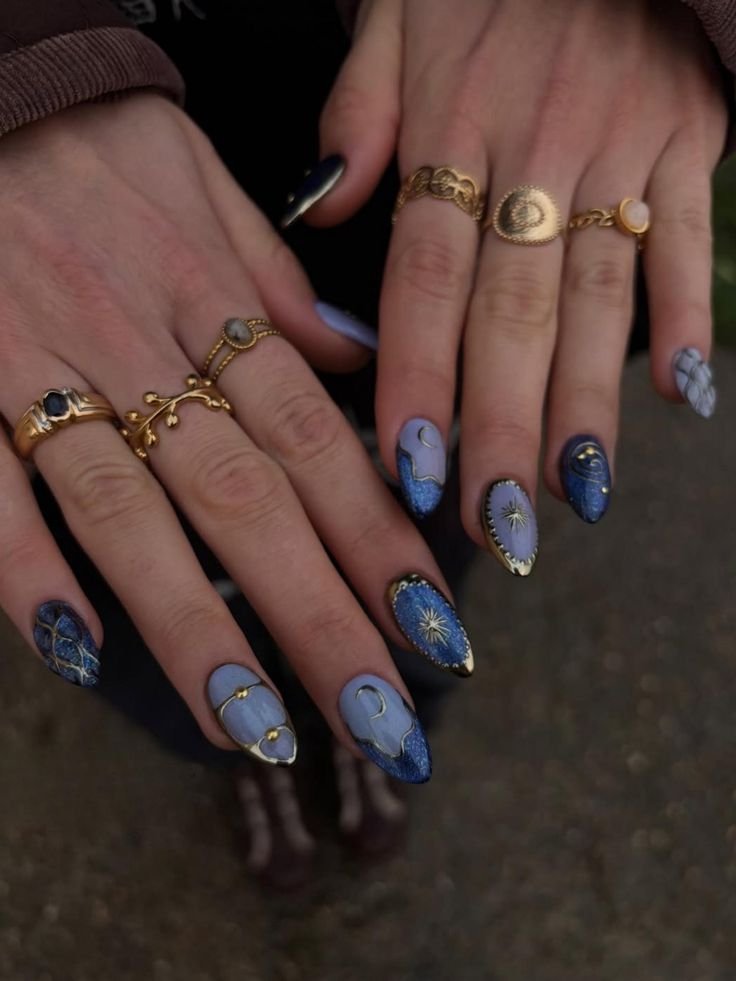Celestial Short Press On Nails _ Midnight Blue Lavender Nails _ Sun Moon Star Nail Art _ Luxury Cosmic Nail Design _ Almond Nails _ DC966H Stylish blue nails with celestial designs and gold rings, showcasing a cosmic-themed manicure and elegant jewelry. - Handy Home Stylish blue nails with celestial designs and gold rings, showcasing a cosmic-themed manicure and elegant jewelry.