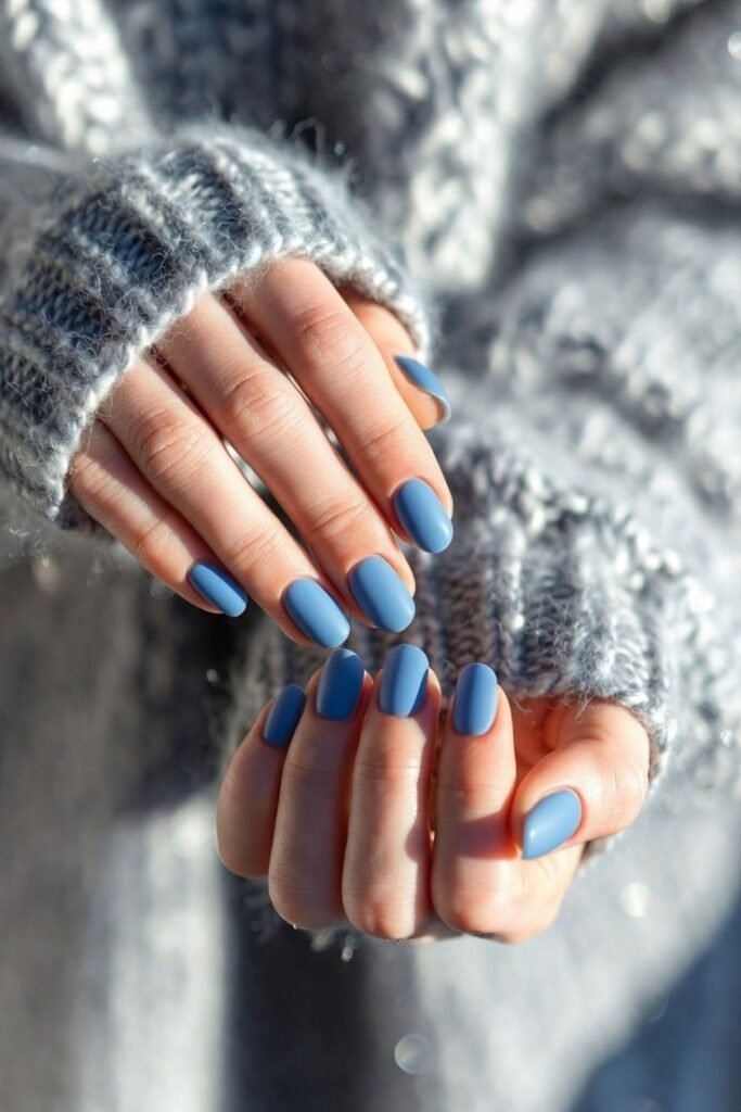 Icy Blue Winter Nails ❄️ Close-up of hands in a cozy gray sweater, showcasing elegant blue matte nail polish. - Handy Home Close-up of hands in a cozy gray sweater, showcasing elegant blue matte nail polish.