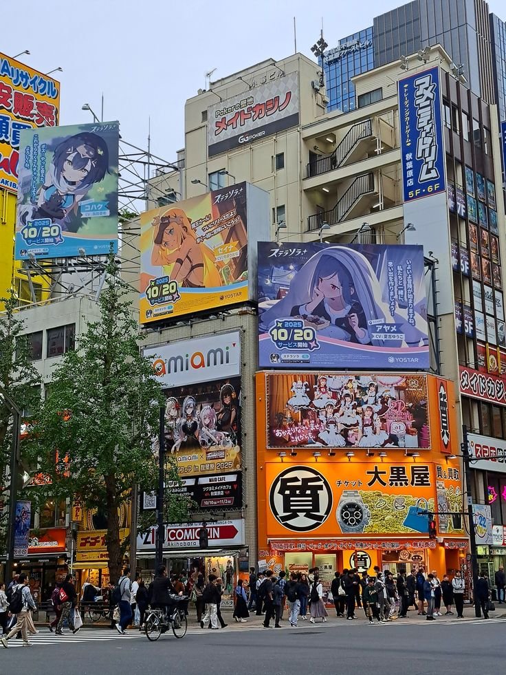 Street view of Akihabara, Tokyo featuring vibrant anime billboards and bustling pedestrians.