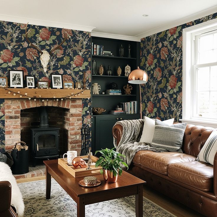 NextWall 30_75-sq ft Midnight Blue and Carmine Non-woven Floral Self-adhesive Peel and Stick Wallpaper _ HG14202 Cozy living room with floral wallpaper, leather sofa, and rustic fireplace. Warm lighting and decor create an inviting atmosphere. - Handy Home Cozy living room with floral wallpaper, leather sofa, and rustic fireplace. Warm lighting and decor create an inviting atmosphere.