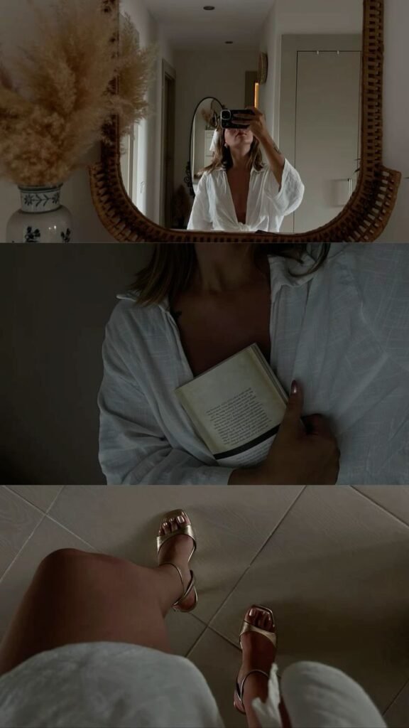 On its own_ photography lifestyle photo Woman in white robe taking a mirror selfie, holding a book, gold sandals shown. Cozy and elegant home vibe. - Handy Home Woman in white robe taking a mirror selfie, holding a book, gold sandals shown. Cozy and elegant home vibe.