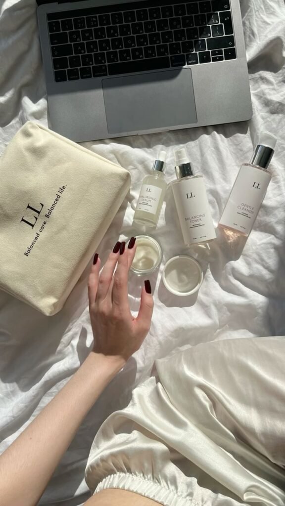 Luxurious skincare set with laptop on bed. Includes cleanser, toner, serum, and cream. Perfect for a balanced beauty routine.