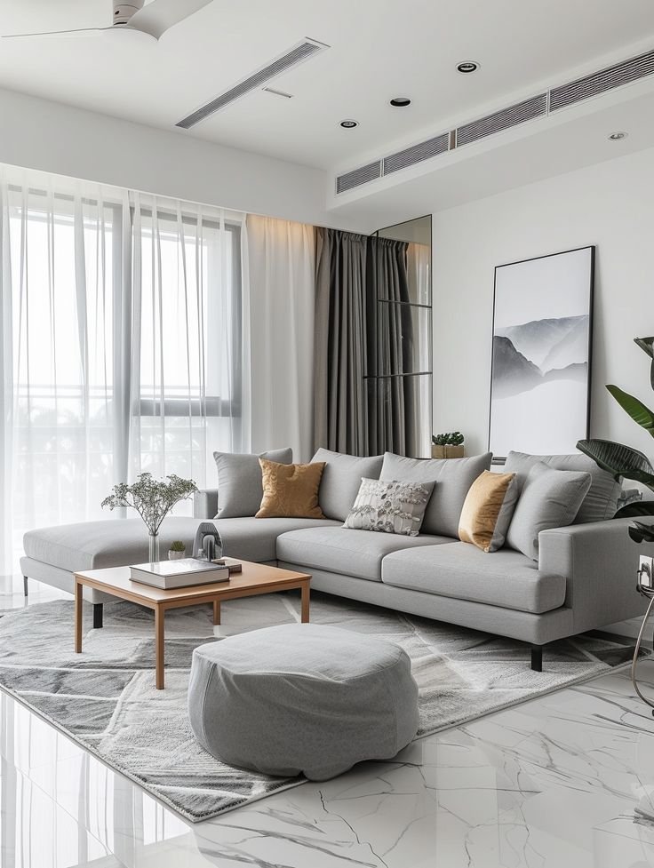 Modern living room with a gray sectional sofa, cozy cushions, a wooden coffee table, and stylish decor in a bright, airy space.
