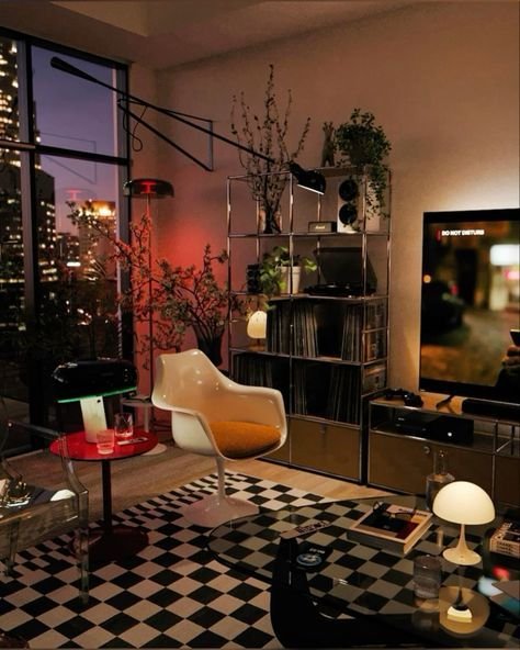 Cozy urban living room with retro decor, city view, checkered rug, stylish chair, and ambient lighting at dusk.