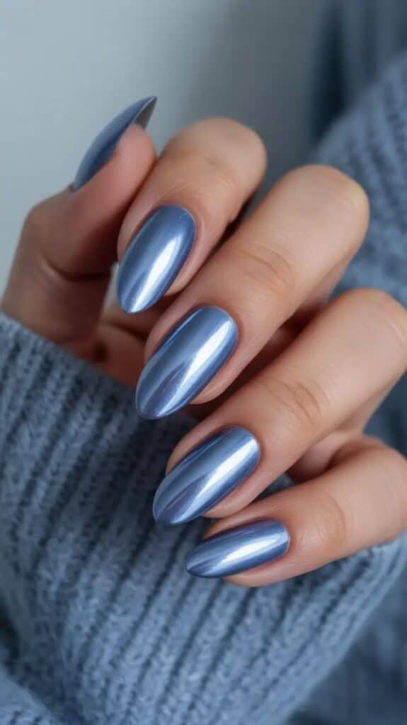 nail colors 2026_ Metallic Frosted Blue Metallic blue chrome nails with a glossy finish. Perfect manicure on a hand in a cozy sweater, ideal for elegant, modern style. - Handy Home Metallic blue chrome nails with a glossy finish. Perfect manicure on a hand in a cozy sweater, ideal for elegant, modern style.