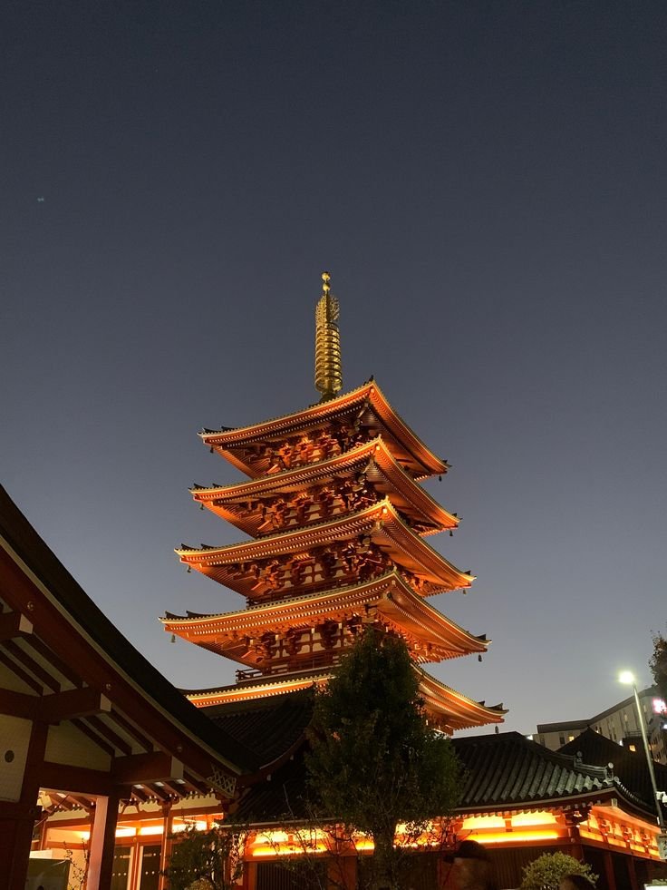 Illuminated five-story pagoda at night against a clear sky, showcasing traditional Japanese architecture.